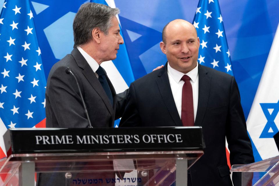 U.S. Secretary of State Antony Blinken and Israeli Prime Minister Naftali Bennett stand in front of flags and behind a podium that reads: Prime Minister's Office.