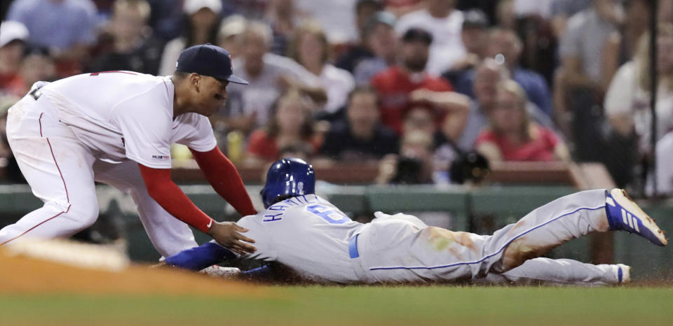 Boston Red Sox third baseman Rafael Devers, left, tags out Kansas City Royals' Billy Hamilton, right, who tried to advance to third on a flyout during the fourth inning of a baseball game at Fenway Park in Boston, Wednesday, Aug. 7, 2019. (AP Photo/Charles Krupa)