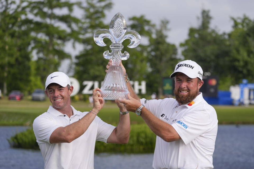 Rory McIlroy, of Northern Ireland, and teammate Shane Lowry, of Ireland, right hold up their trophy after winning the PGA Zurich Classic golf tournament at TPC Louisiana in Avondale, La., Sunday, April 28, 2024. (AP Photo/Gerald Herbert)