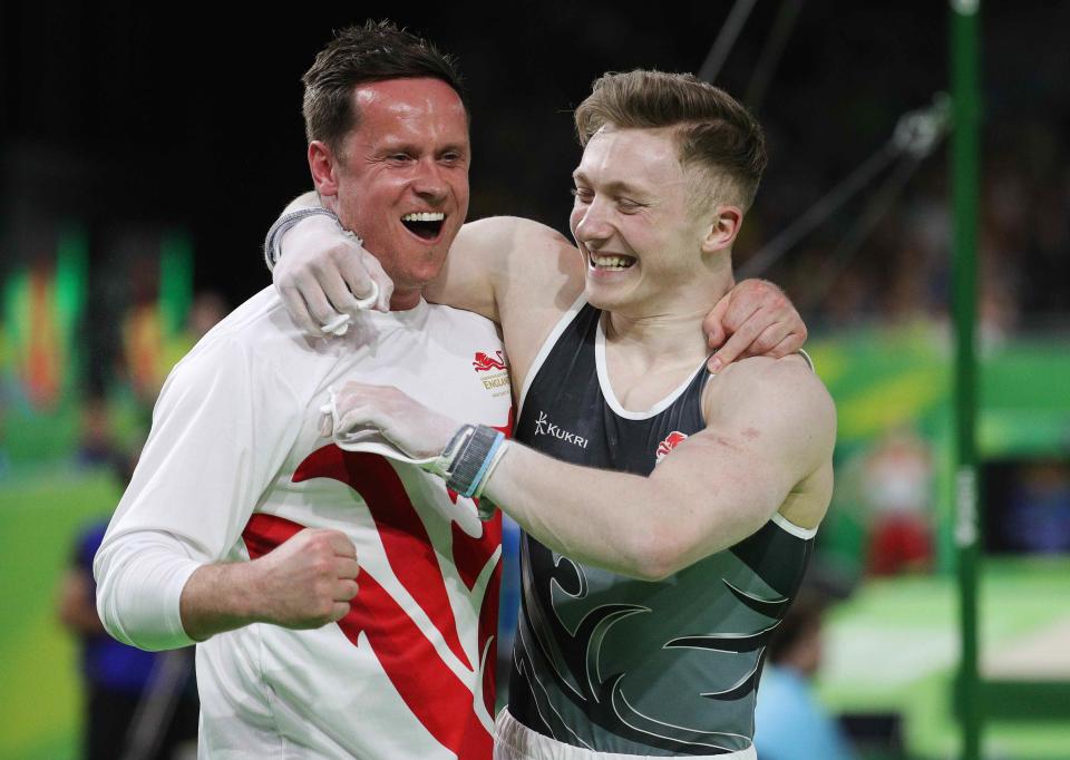 Nile Wilson of England celebrates with coach Barry Collie after winning the gold. REUTERS/Athit Perawongmetha