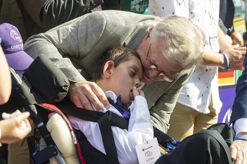 Disabled teen Cody Dorman, seen Nov. 4 at Santa Anita celebrating with trainer Bill Mott the second Breeders' Cup win by his namesake, Cody's Wish, died the following day on his way home to Kentucky. Benoit photo, courtesy of Santa Anita