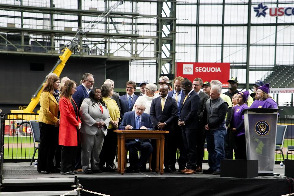 Wisconsin Gov. Tony Evers signs Assembly Bill 438 and Assembly Bill 439 at American Family Field Tuesday, Dec. 5, 2023, in Milwaukee. The bills use public funds to help the Milwaukee Brewers repair their stadium over the next three decades. (AP Photo/Morry Gash)