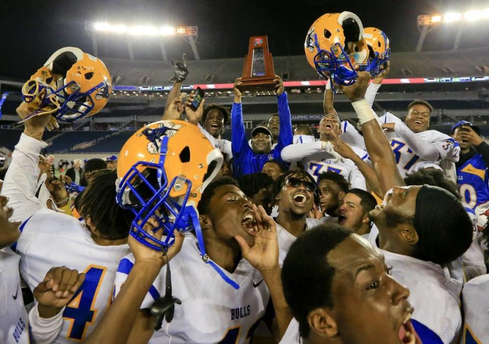 Miami Northwestern Bulls head coach Max Edwards holds the championship trophy as the team celebrates after defeating Armwood Hawks 21-16 in Class 6A state high school football championship in Orlando on Friday, Dec. 8, 2017. DaMarco Keshaun Harris, who was on that team, was shot to death Thursday, May 9, 2024, in a Midtown Miami parking lot.