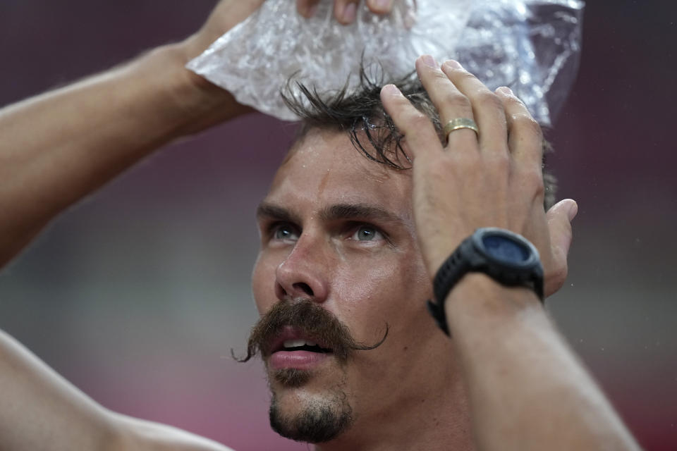 Adam Helcelet, of the Czech Republic, cools down with ice during the high jump of the decathlon at the 2020 Summer Olympics, Wednesday, Aug. 4, 2021, in Tokyo. (AP Photo/Matthias Schrader)