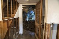 Dirt spills through a collapsed foundation of a home on Aug. 10, 2023, in Highland Falls, N.Y., following flooding. New York could soon require people selling their homes to disclose whether their properties have been flooded or are at risk for future flooding. (AP Photo/Mary Conlon)