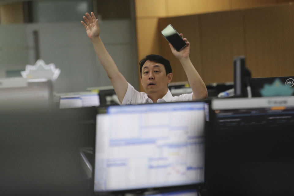 A currency trader gestures at the foreign exchange dealing room of the KEB Hana Bank headquarters in Seoul, South Korea, Thursday, July 9, 2020. Asian stock markets followed Wall Street higher on Thursday following gains for major U.S. tech stocks. (AP Photo/Ahn Young-joon)