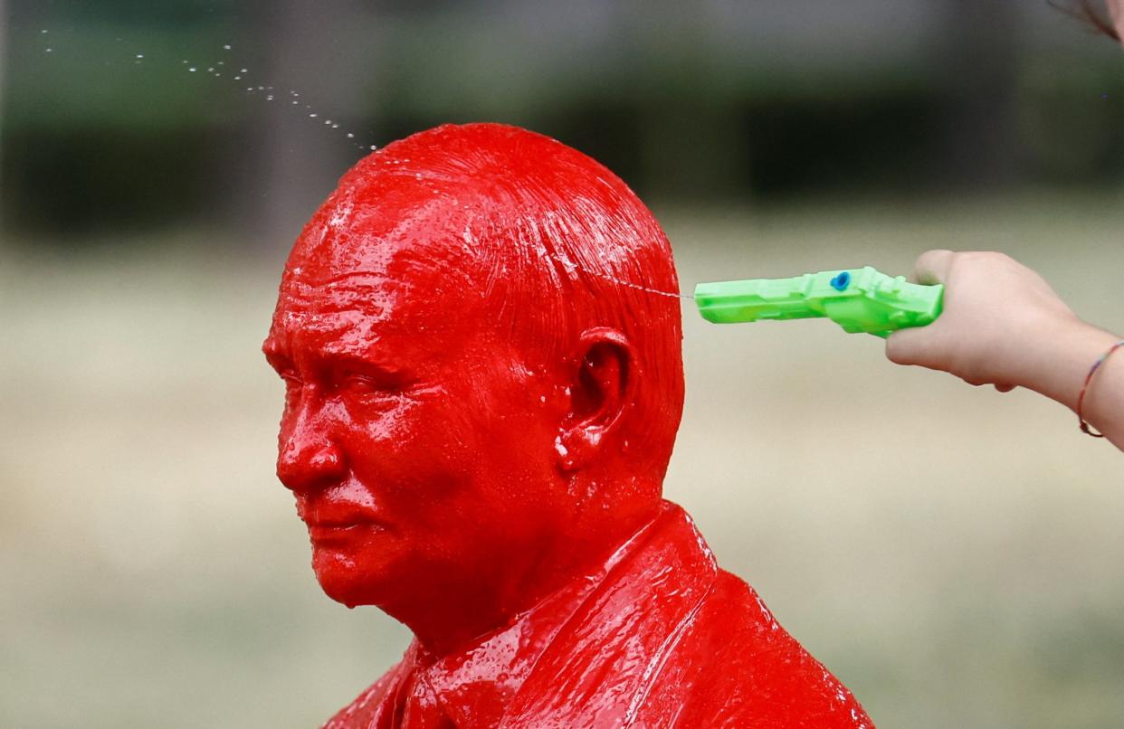 A child points a water pistol at a life-size statue of Russian President Vladimir Putin riding a tiny tank created by French artist James Colomina in Villa Borghese in Rome (REUTERS)