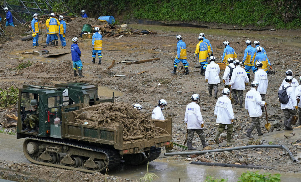 Police officers continue a search operation for missing persons at the site of a mudslide in Tsunagi town, Kumamoto prefecture, southwestern Japan, Tuesday, July 7, 2020. Floodwaters flowed down streets in southwestern Japanese towns hit by deadly rains that were expanding across the region Tuesday. (Koji Harada/Kyodo News via AP)