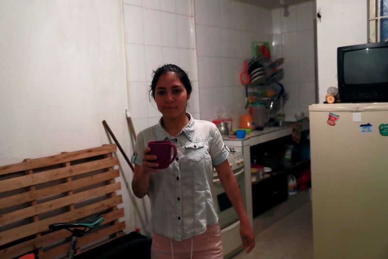 Jetsymar Torres from Venezuela holds a mug in her houses in Bogota