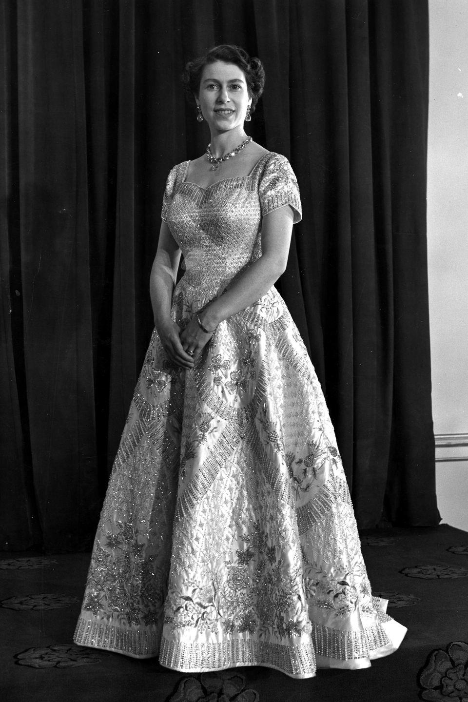 <p>In an embellished, cap-sleeved Norman Hartnell gown for her coronation ceremony. </p>