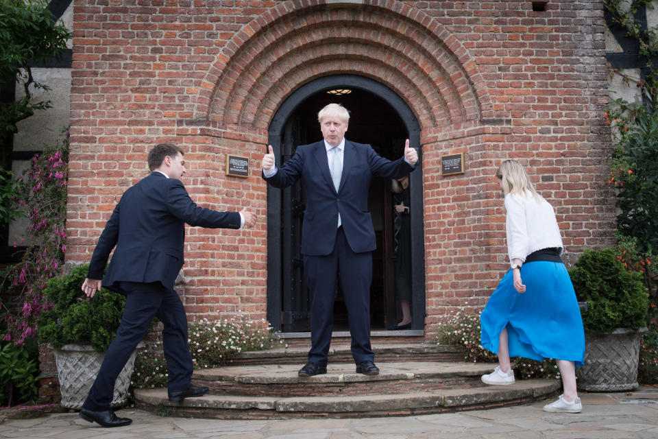 Conservative party leadership candidate Boris Johnson (centre) gestures to visitors as his staff members walk up the steps, during a tour of the RHS (Royal Horticultural Society) garden at Wisley, in Surrey.