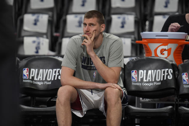 Denver Nuggets center Nikola Jokic looks on as teammates warm up before Game 2 of an NBA second-round playoff series against the Phoenix Suns, Monday, May 1, 2023, in Denver. (AP Photo/David Zalubowski)