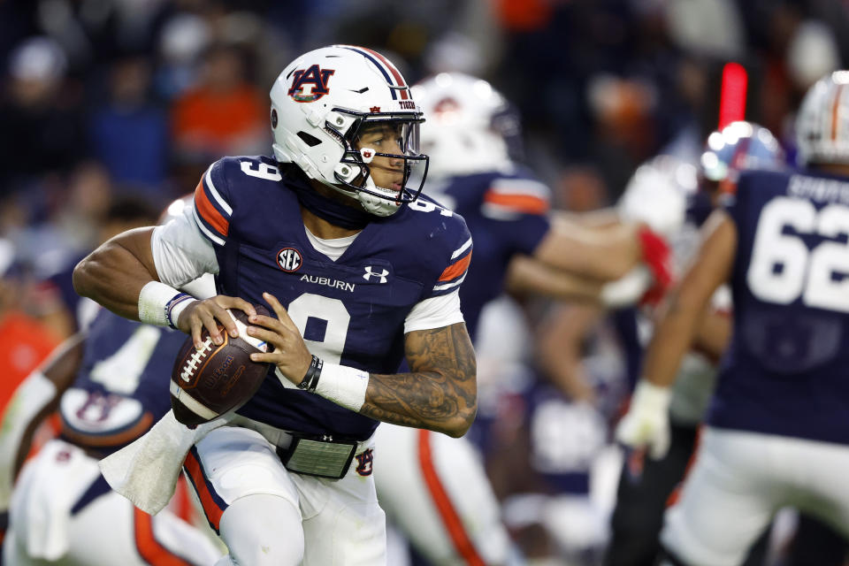 Auburn quarterback Robby Ashford (9) rolls out to pass against Western Kentucky during the first half of an NCAA college football game Saturday, Nov. 19, 2022, in Auburn, Ala. (AP Photo/Butch Dill)