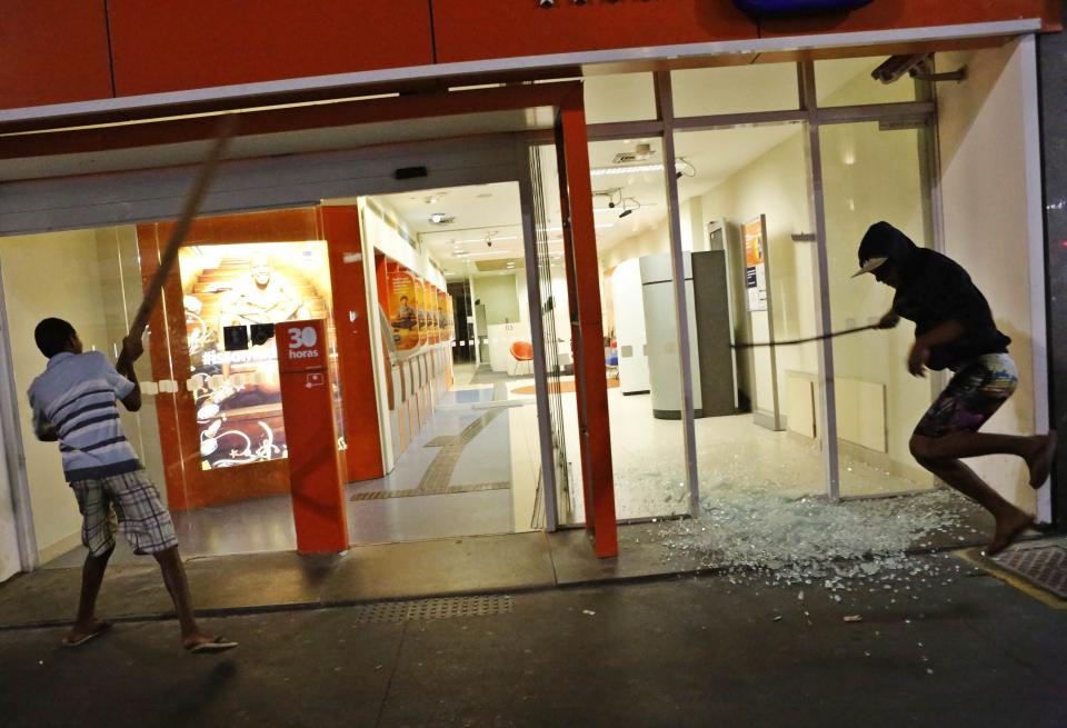 Demonstrators attack an Itau bank branch during a protest against the 2014 World Cup, in Sao Paulo May 15, 2014. CupRoad blocks and marches hit Brazilian cities on Thursday as disparate groups criticized spending on the upcoming World Cup soccer tournament and sought to revive a call for better public services that swept the country last June. REUTERS/Nacho Doce (BRAZIL - Tags: CIVIL UNREST SPORT SOCCER WORLD CUP)