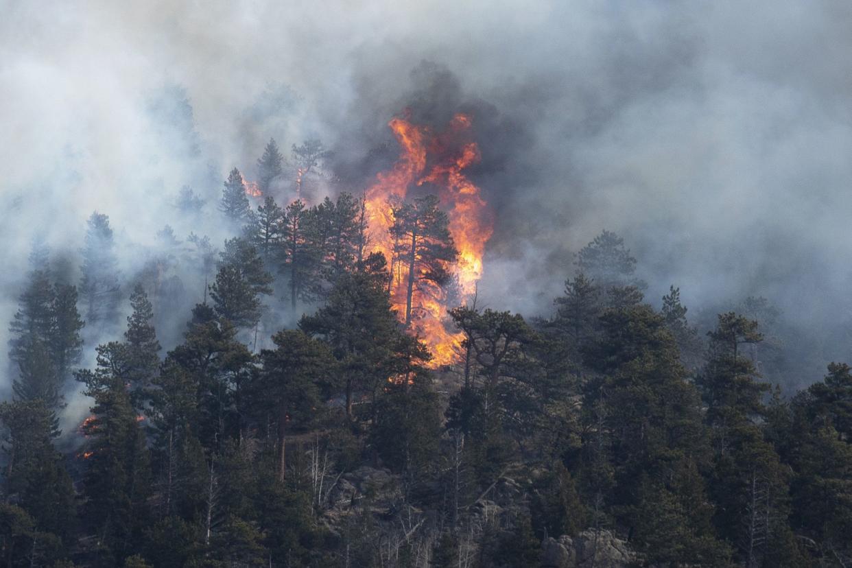 Spot fires burn from the Kruger Rock Fire flare up on Tuesday, Nov. 16, 2021, in Estes Park, Colo. Authorities say a pilot died after crashing while fighting the wildfire burning near Rocky Mountain National Park on Tuesday. 