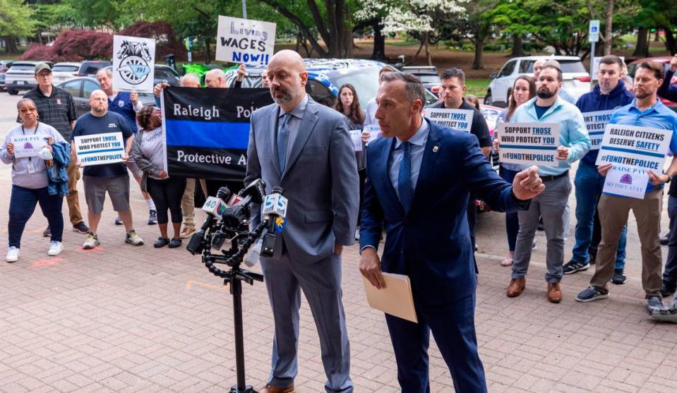 Matthew Cooper, president, left, and Rick Armstrong, spokesperson, of the Raleigh Police Protective Association along with dozens of police officers, demand higher pay from the city of Raleigh during a rally outside city hall on Tuesday, April 9, 2024.