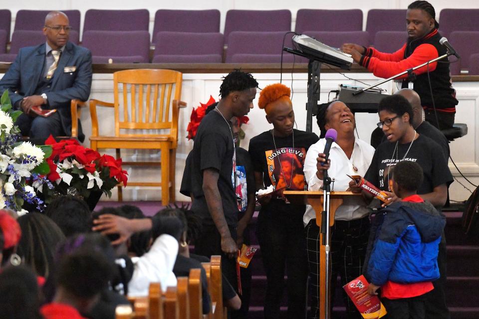 Overcome with emotion Chantel Brown with her family surrounding her struggles to sing a solo of the gospel song "I Just Can't Give Up Now" during the funeral for her slain 13-year-old son, Prince Holland.