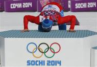 Russia's Alexander Legkov kisses the winners podium during the flower ceremony for the men's cross-country 50 km mass start free event at the Sochi 2014 Winter Olympic Games February 23, 2014. REUTERS/Stefan Wermuth