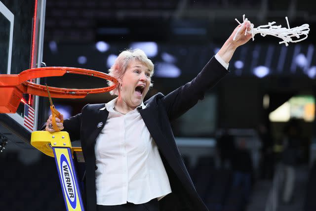 <p>Andy Lyons/Getty</p> Lisa Bluder of the Iowa Hawkeyes cuts down the net after beating the LSU Tigers in the Elite 8 round of the NCAA Women's Basketball Tournament in April 2024.