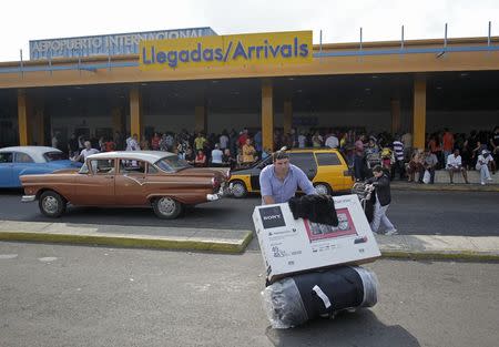 A passenger pushes a luggage cart after arriving on a charter flight from Tampa, Florida, at the airport in Havana January 15, 2015. REUTERS/Stringer