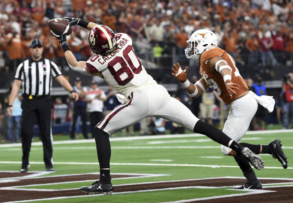 Oklahoma tight end Grant Calcaterra (80) hauls in a touchdown pass from quarterback Kyler Murray in front Texas defensive back Brandon Jones during the first half of the Big 12 Conference championship NCAA college football game on Saturday, Dec. 1, 2018, in Arlington, Texas. (AP Photo/Jeffrey McWhorter)