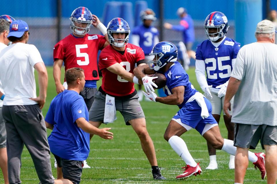 New York Giants quarterback Daniel Jones (8) hands the ball to running back Matt Breida (31) on the first day of mandatory minicamp at the Giants training center in East Rutherford on Tuesday, June 13, 2023.