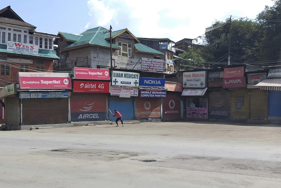 A Kashmiri plays cricket in a deserted area during curfew in Srinagar, Indian controlled Kashmir, Thursday, Aug. 8, 2019. The lives of millions in India's only Muslim-majority region have been upended since the latest, and most serious, crackdown followed a decision by New Delhi to revoke the special status of Jammu and Kashmir and downgrade the Himalayan region from statehood to a territory. Kashmir is claimed in full by both India and Pakistan, and rebels have been fighting Indian rule in the portion it administers for decades. (AP Photo/Sheikh Saaliq)