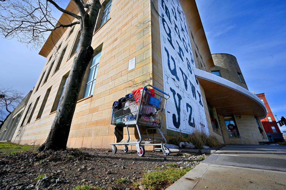 WORCESTER - A shopping cart full of clothes and plastic bags sits outside the main branch of the Worcester Public Library.