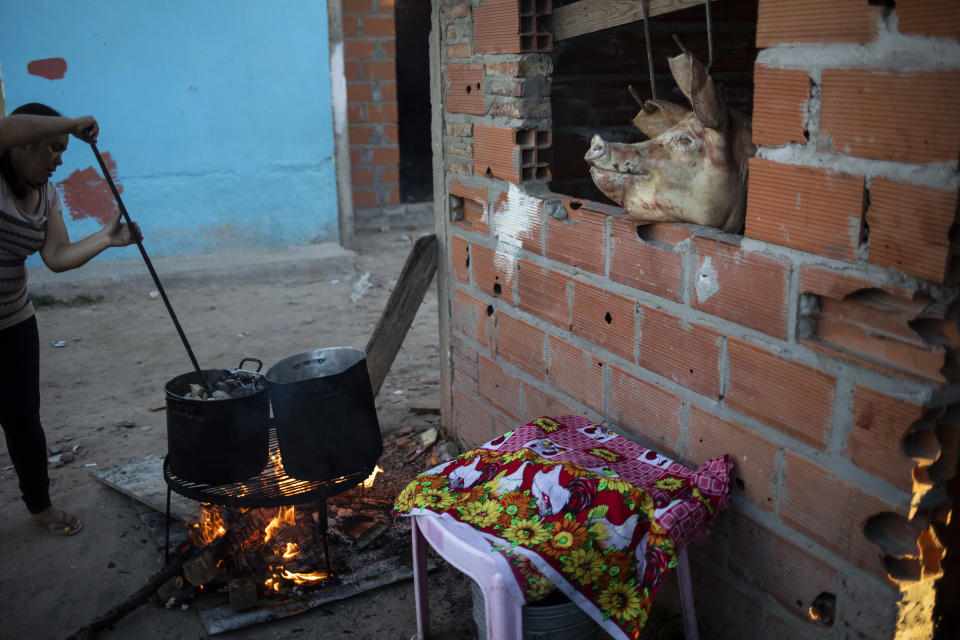 A woman cooks a pig stew over a wood fire to sell in the Via Honda neighborhood of Rosario, Argentina, Monday, April 26, 2021. In Pope Francis’ home country, the Roman Catholic Church is still the dominant religion, but a survey by the council found that the percentage of Argentine Catholics fell between 2008 and 2019 while the share of evangelicals grew. (AP Photo/Rodrigo Abd)