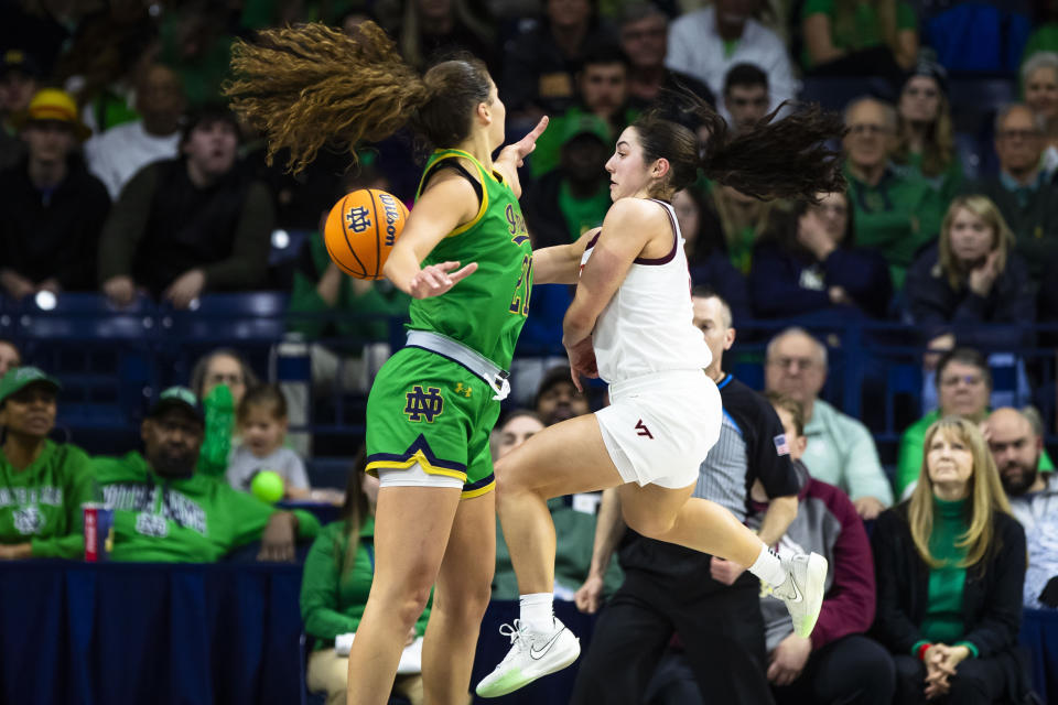 Virginia Tech guard Georgia Amoore, right, passes the ball around Notre Dame forward Maddy Westbeld, left, during the second half of an NCAA college basketball game Thursday, Feb. 29, 2024, in South Bend, Ind. (AP Photo/Michael Caterina)