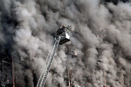 Firefighters try to put out a fire in a blazing high-rise building in Tehran, Iran January 19, 2017. Tasnim News Agency/Handout via REUTERS