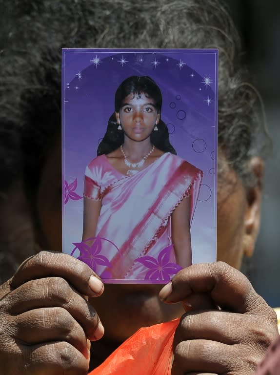 A Sri Lankan woman holds a photograph of a family member who disappeared during the country's civil war at a silent protest in Jaffna on September 2, 2016