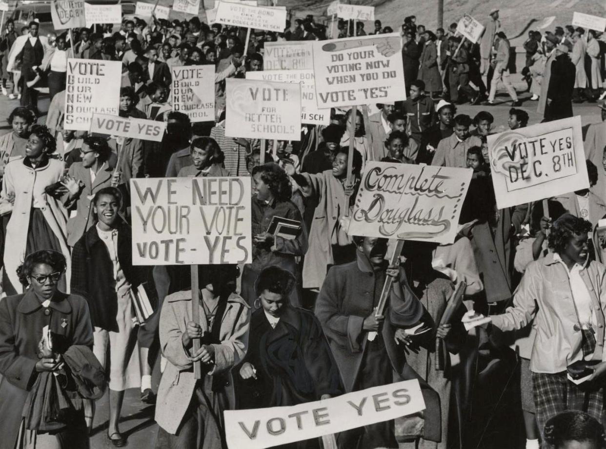 Douglass High School students carry signs asking Oklahoma City area voters to "Complete Douglass," "Vote Yes Dec. 8th" and simply "Vote Yes" during a parade in support of an upcoming school bond issue in 1953. Part of a nearly $3.9 million city-county bond issue for schools, roads and river floodway was a request for $1 million that would mostly go toward completing a new building for Frederick A. Douglass High School. This photo was published in The Daily Oklahoman on Election Day, Dec. 8, 1953, when voters approved the school bond issue that would complete the new high school building, as well as go toward schools at Spencer and Arcadia and target overcrowding at two elementary schools. The first public use of the new Douglass High School was graduation in May 1954.