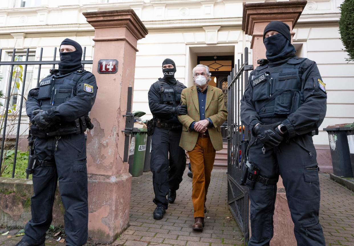 Police officers lead Heinrich XIII Prince Reuss to a police vehicle during a raid in Frankfurt, Germany on Dec. 7, 2022.