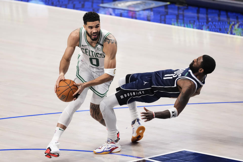 Boston Celtics forward Jayson Tatum (0) drives to the basket against Dallas Mavericks guard Kyrie Irving (11) during the first half in Game 4 of the NBA basketball finals, Friday, June 14, 2024, in Dallas. (AP Photo/Sam Hodde)