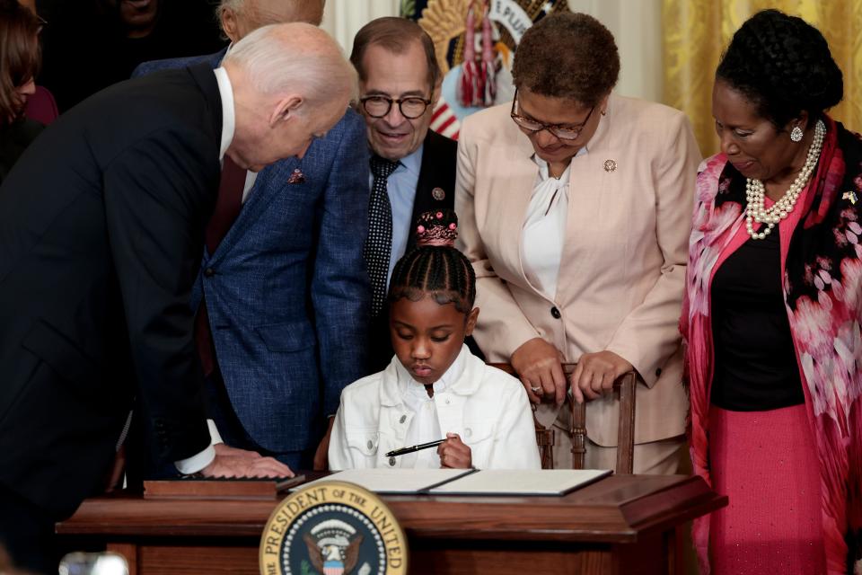 George Floyd's daughter Gianna holds a pen President Joe Biden used to sign an executive order enacting police reform on May 25, 2022.