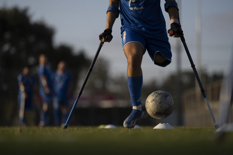 An Israel Amputee Football Team soccer player controls the ball during a practice session in Ramat Gan, Thursday, April 11, 2024. Amputee football stands out as a disability sport because the athletes aren't in wheelchairs. It is played with six outfield players who have lower extremity amputations and play with crutches and without prosthetics. (AP Photo/Leo Correa)