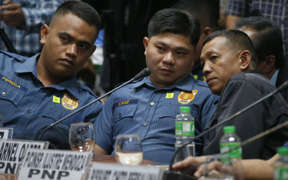 FILE - In this Aug. 24, 2017, file photo, from left; police officers Jeremias Pereda, Jerwin Cruz and Arnel Oares talk during a senate hearing on the killing of Kian Loyd Delos Santos, a 17-year-old Grade 11 student, allegedly during a drug crackdown in Manila, Philippines. A Philippine court has found the three officers guilty of the killing of Delos Santos in the first known such conviction under the president's crackdown on drugs. (AP Photo/Bullit Marquez, File)