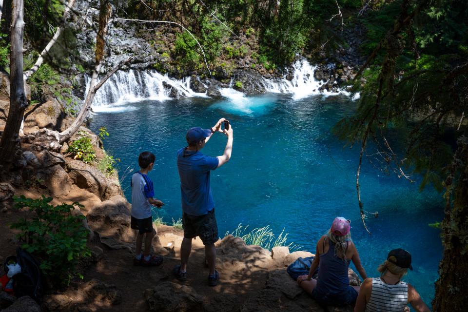 Visitors enjoy the view from the rim of Tamolitch Falls, also known as Blue Pool, east of Springfield.