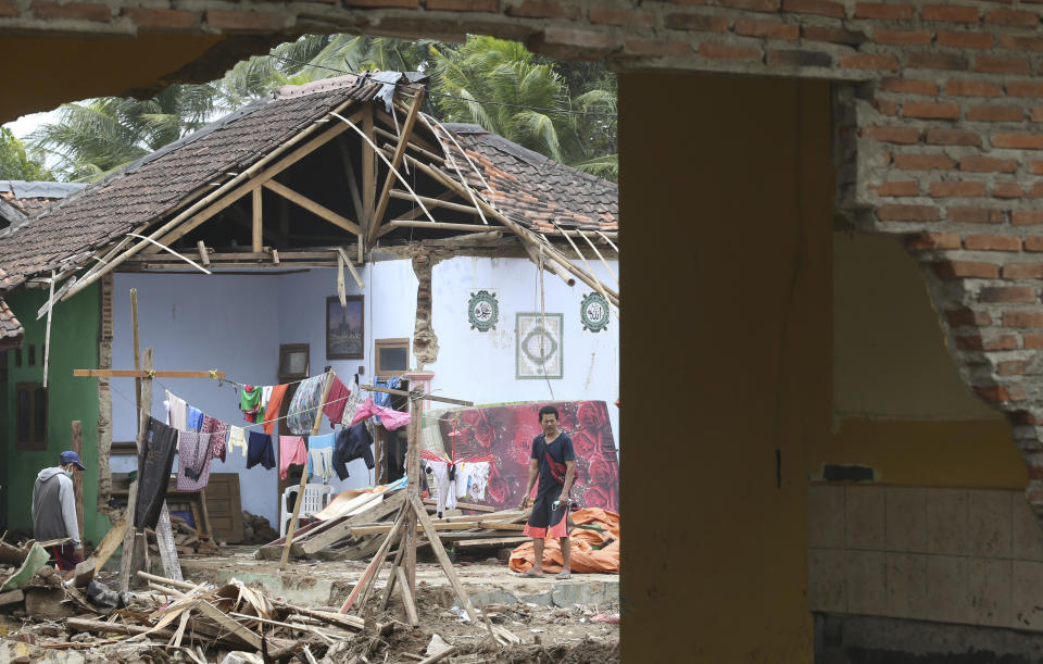 A man removes debris from his damaged home in the tsunami-hit village of Carita, Indonesia, Friday, Dec. 28, 2018. Indonesia has widened the no-go zone around an island volcano that triggered a tsunami on the weekend, killing hundreds of people in Sumatra and Java. (AP Photo/Achmad Ibrahim)