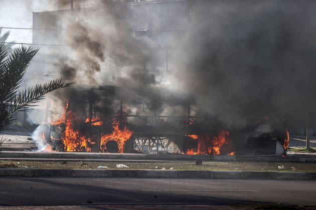 Flames and smoke rise from a bus hit by an Israeli attack in Salah al-Din Road, central Deir al Balah, Gaza.