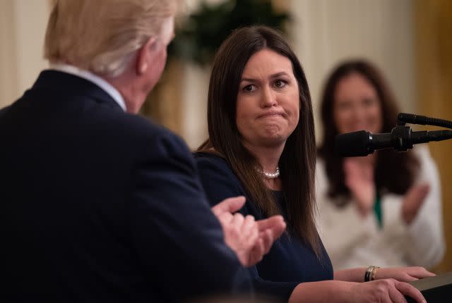 Donald Trump claps toward his White House press secretary Sarah Huckabee Sanders