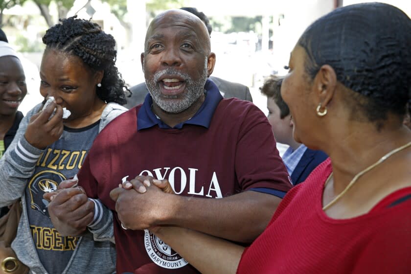 Andrew Wilson, center, holds hands with his daughters, Catrina Burks, left, and Gwen Wilson, as he leaves the Men's Central Jail in Los Angeles, Thursday, March 16, 2017. Wilson, whose murder conviction was tossed by a California judge is free after 32 years in prison. (AP Photo/Nick Ut)