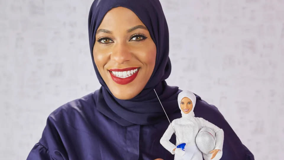 Ibtihaj Muhammad mit der Barbie, die einen Hidschab trägt. (Mattel/PA)
