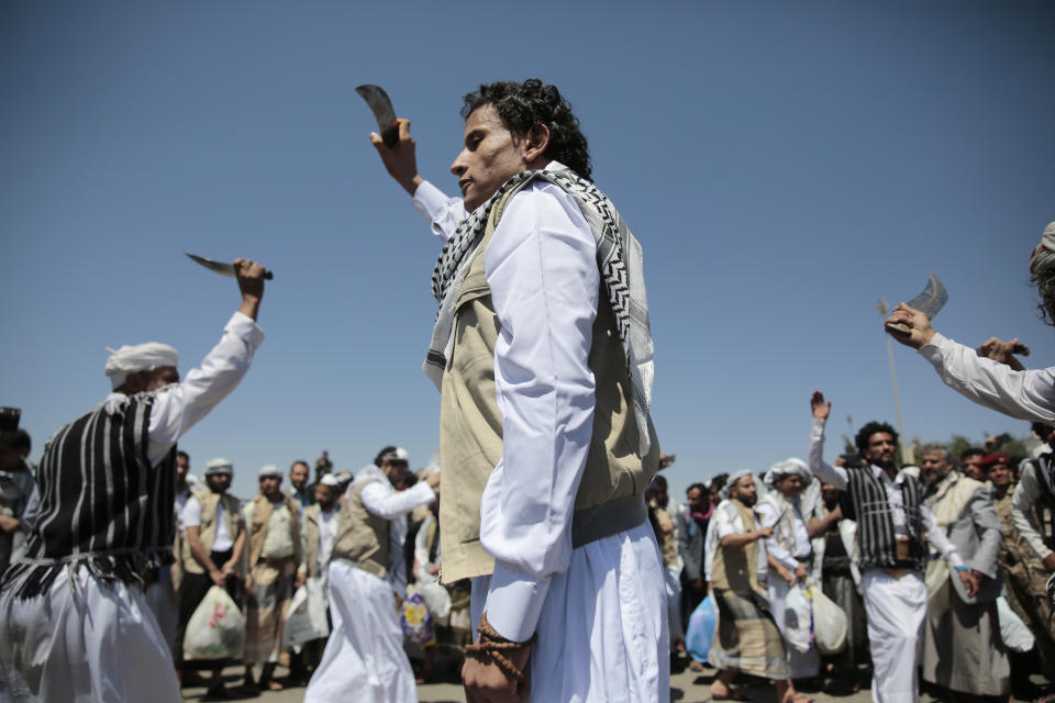 A Yemeni prisoner, center, performs a traditional dance during his arrival after being released by the Saudi-led coalition at the airport in Sanaa, Yemen, Friday, Oct. 16, 2020. Yemen's warring sides completed a major, U.N.-brokered prisoner swap on Friday, officials said, a development that could revive the country's stalled peace process after more than five years of grinding conflict. (AP Photo/Hani Mohammed)