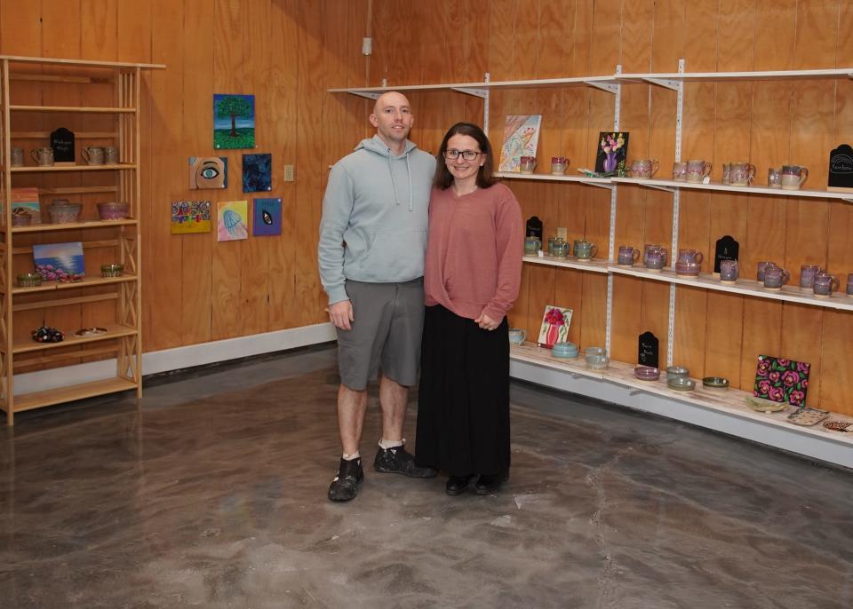 Justin and Kayla Jones pose for a picture at their shop, Justin of the Land and Sea Pottery in downtown Tecumseh.