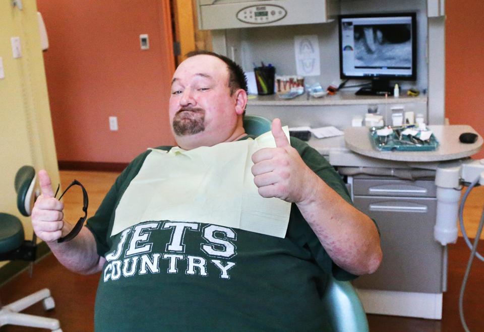 Curtis Cole gives a thumbs up after having three teeth removed, signaling a first step toward a goal to end his pain.