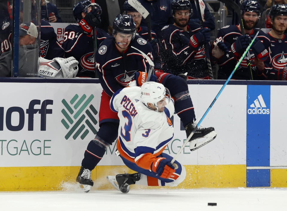 New York Islanders defenseman Adam Pelech, right, collides with Columbus Blue Jackets forward Cole Sillinger during the second period of an NHL hockey game in Columbus, Ohio, Friday, Nov. 25, 2022. (AP Photo/Paul Vernon)