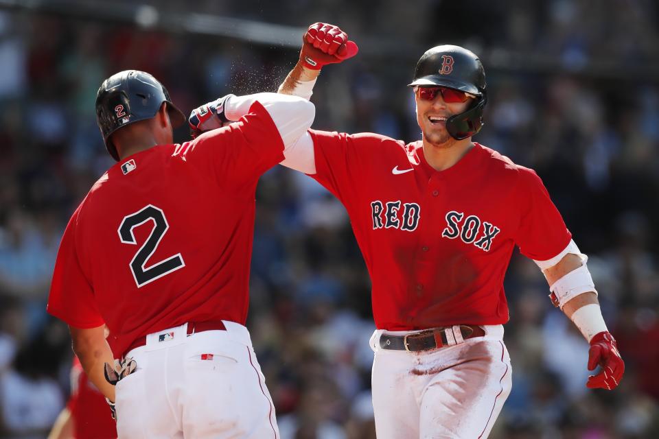 Boston Red Sox's Enrique Hernandez, right, celebrates with Xander Bogaerts (2) after a throwing error by New York Yankees' Rougned Odor allowed Hernandez to score on his triple during the first inning of a baseball game, Saturday, July 24, 2021, in Boston. (AP Photo/Michael Dwyer)