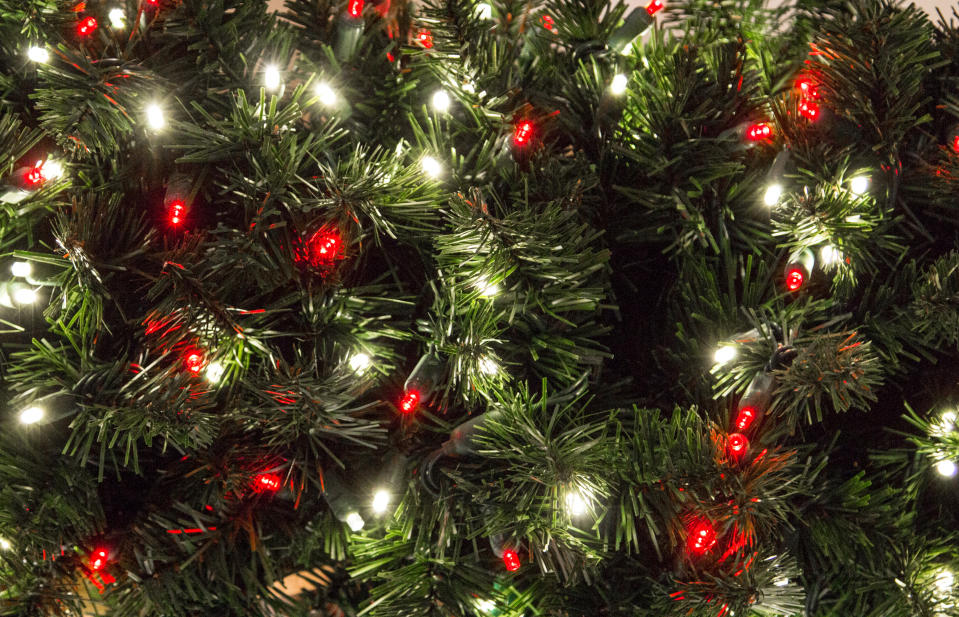 Green Christmas tree with multi colored lights in horizontal orientation with copy space.